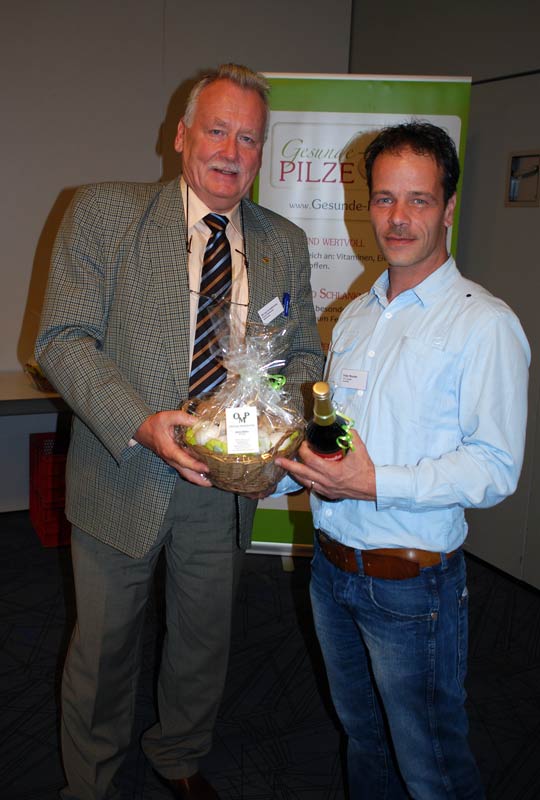 Peter Bouten freut sich über frische Champignons und eine flüssige Spezialität aus Niedersachsen aus den Händen von Michael Schattenberg
